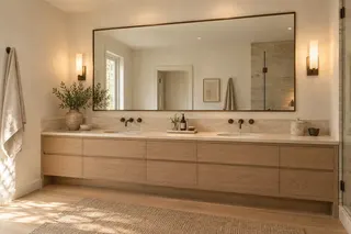 Fulton House — Primary bathroom · a double vanity in pale stone and oak